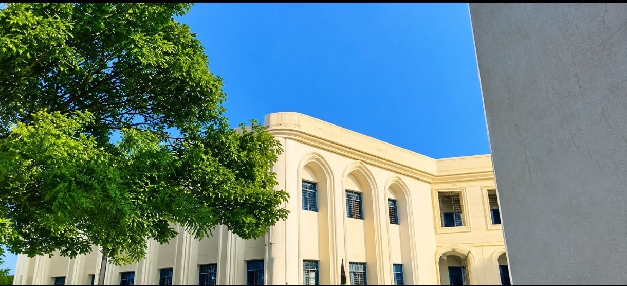 KBNU campus building beneath a clear blue sky